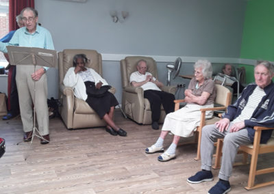 Abbotsleigh Care Home sitting in lounge chairs while watching the choir perform