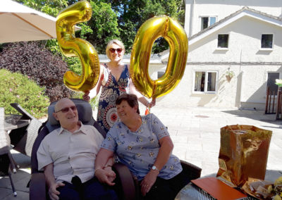 Abbotsleigh Care Home resident and his wife sitting outside in the garden on their 50th anniversary