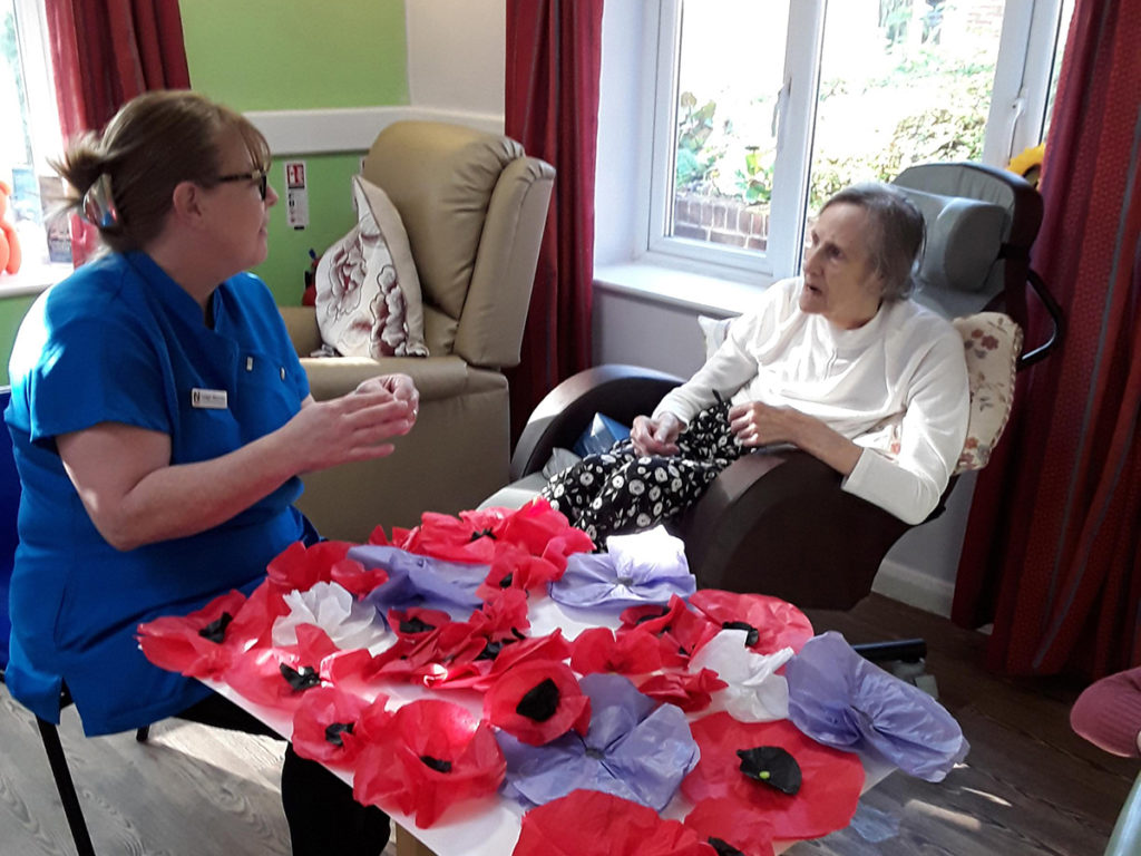 A staff member and resident at Abbotsleigh Care Home making poppies for Remembrance Sunday