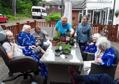 Abbotsleigh residents and staff potting plants outside on the decking