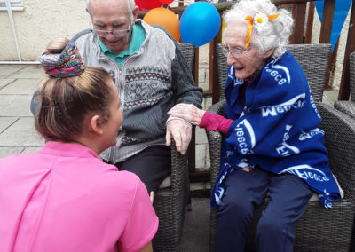 Staff and residents chatting outside at a summer fete