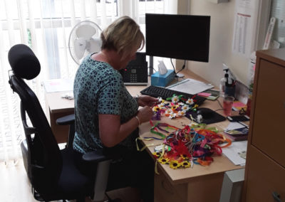 Business Support Officer Louise cutting out flowers and sorting colourful ribbons