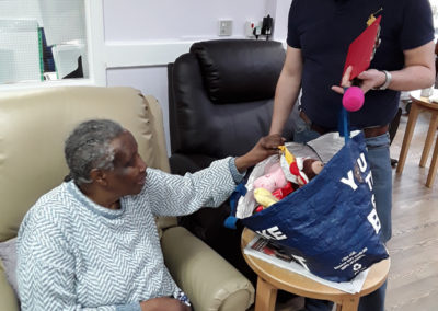Abbotsleigh Care Home resident, reaching into a bag, during a reminiscence session about going on holiday