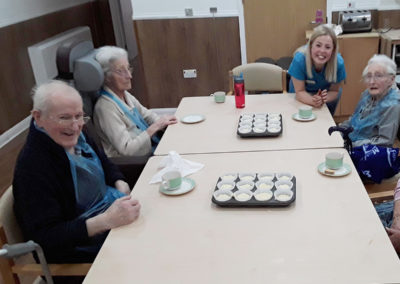 Abbotsleigh Care Home residents sat around a table preparing cupcakes