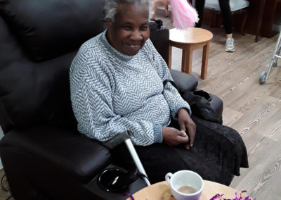 Lady resident at Abbotsleigh Care Home sitting smiling in her chair
