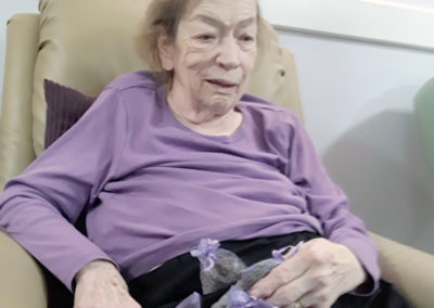 Abbotsleigh Care Home lady resident sitting in a chair holding some bags of lavender