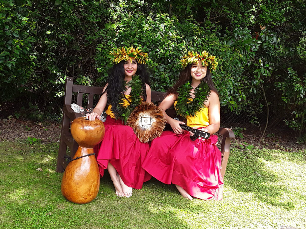 Two Hawaiian hula dancers in full costume in the garden at Abbotsleigh Care Home