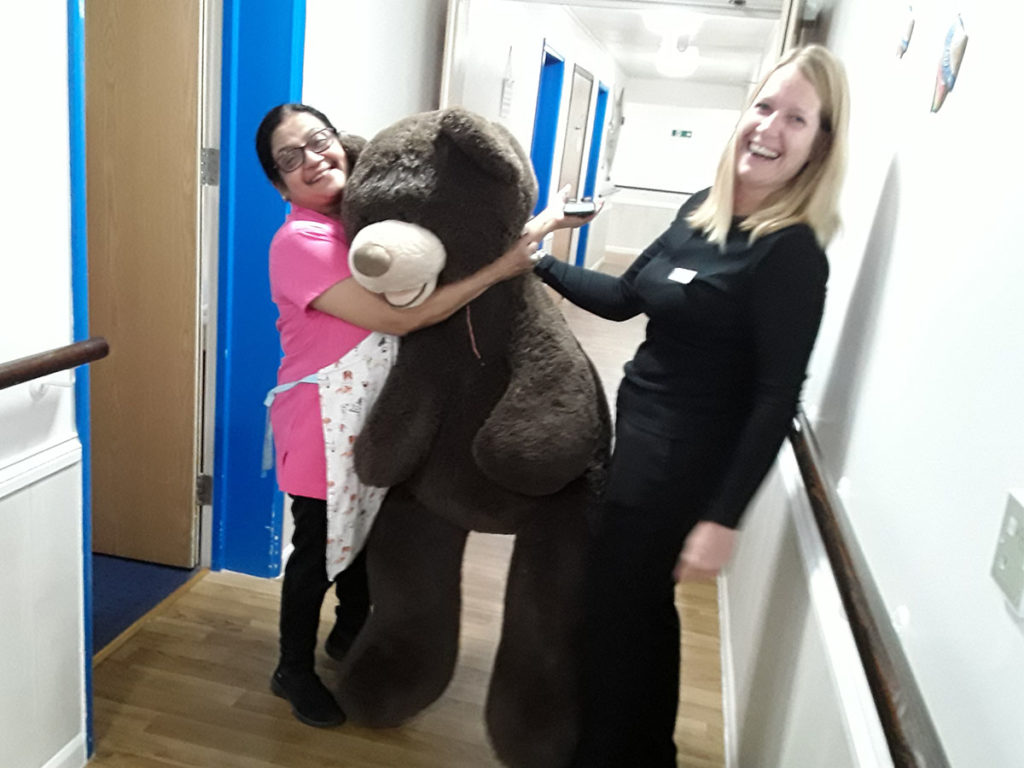 Two Abbotsleigh staff members with a giant brown teddy bear