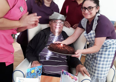 Resident receiving a chocolate cake on his birthday