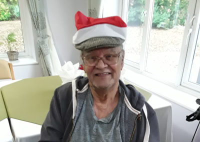 Resident with a Santa hat on top of his flat cap