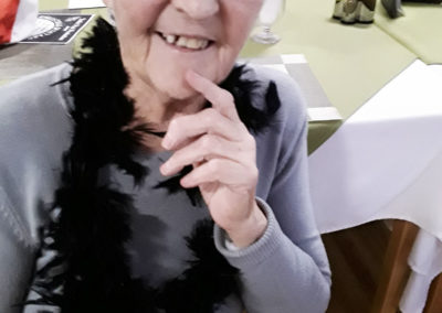 Lady resident at Abbotsleigh Care Home wearing a black feather boa