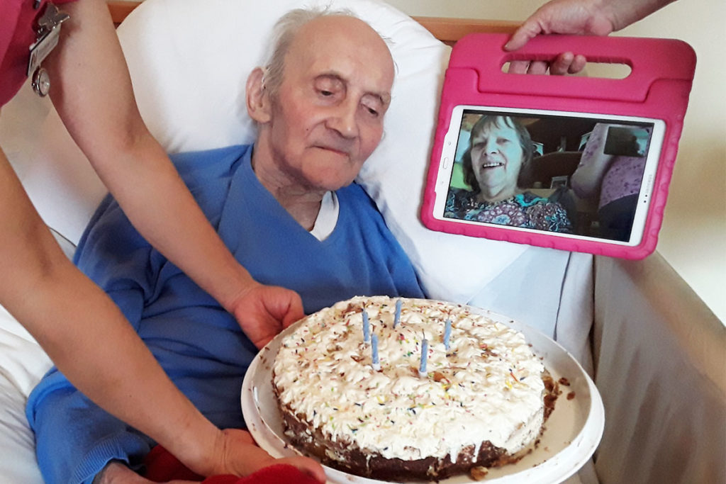 Resident receiving a birthday cake at Abbotsleigh Care Home