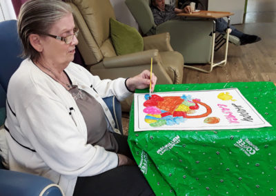 Lady resident painting an Easter picture at Abbotsleigh Care Home