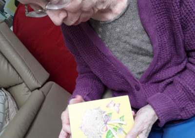 Lady resident at Abbotsleigh Care Home looking at a home made Easter card