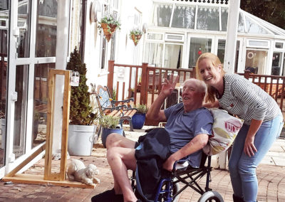Resident in a wheelchair with a staff member enjoying outside together