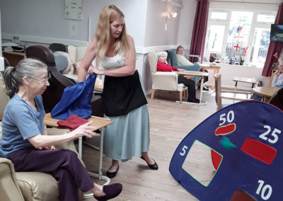 Lady residents playing a target game from her chair at Abbotsleigh Care Home