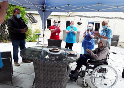 Staff clapping a resident on her birthday outside at Abbotsleigh Care Home