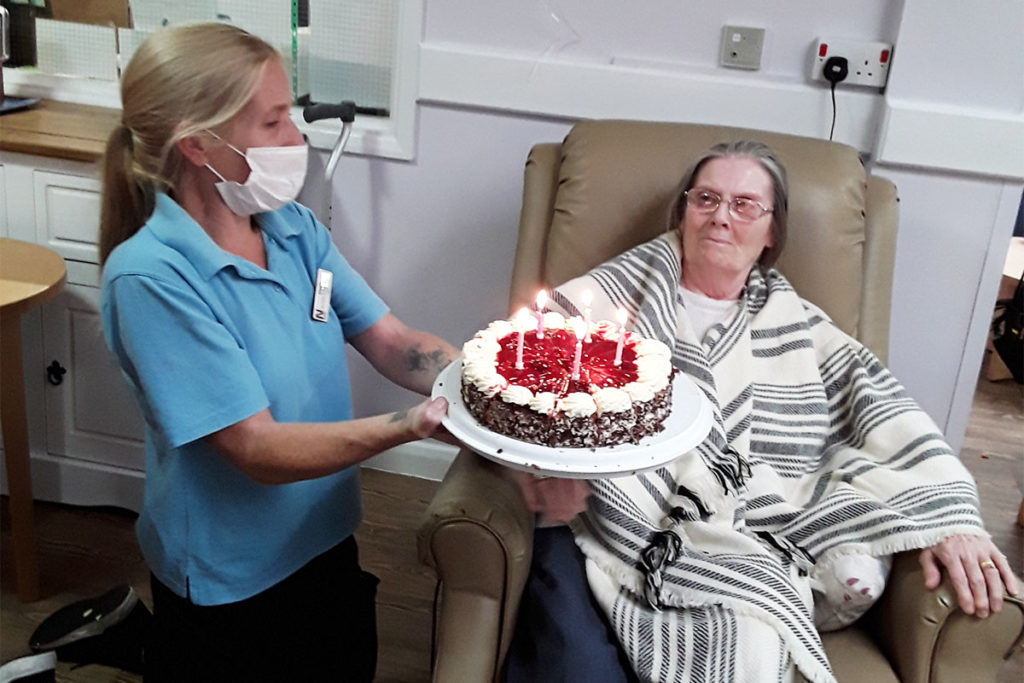 Lady resident receiving her birthday cake at Abbotsleigh Care Home