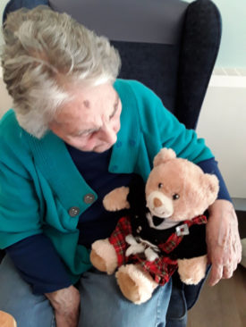 Abbotsleigh Care Home resident cuddling a Scottish teddy bear