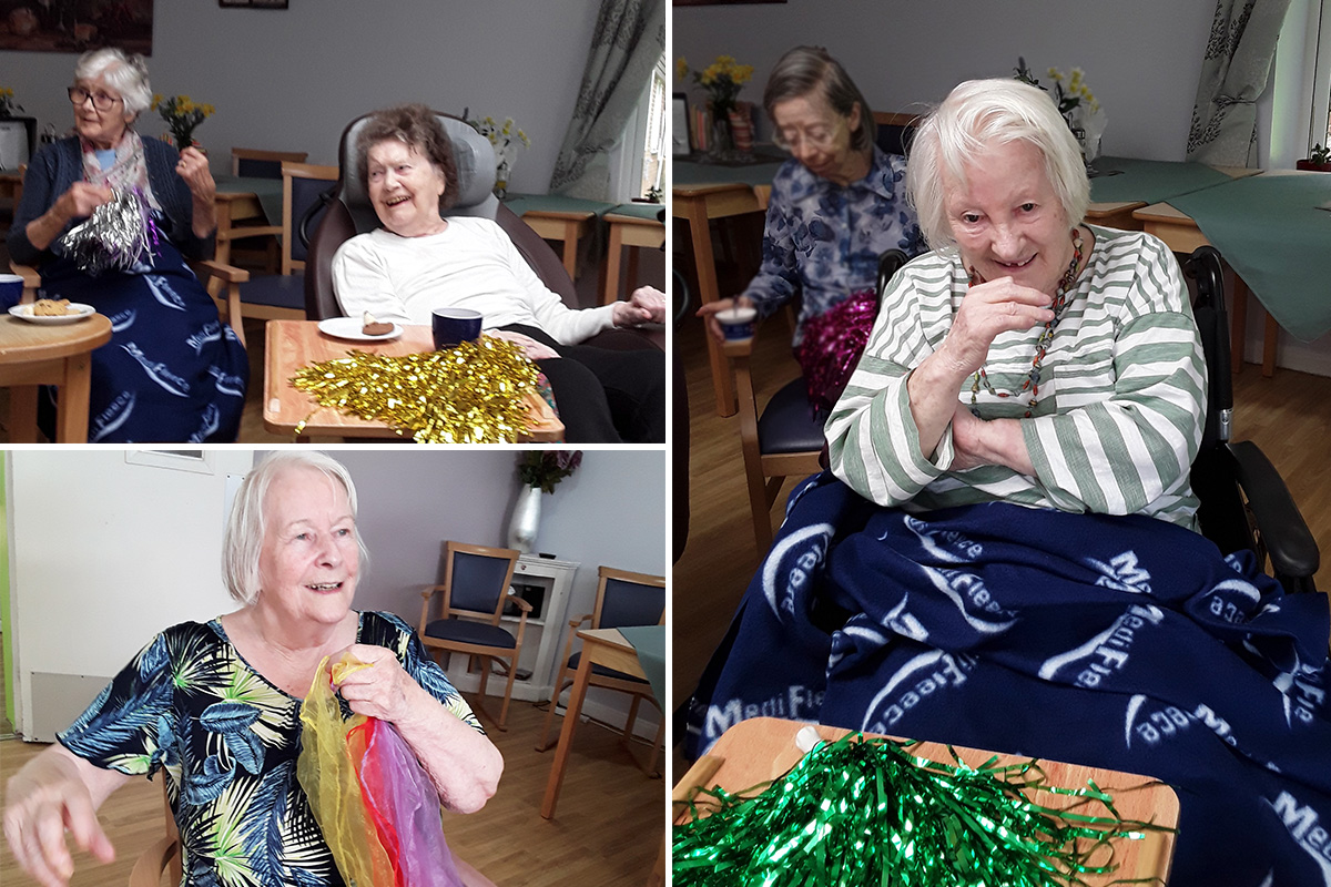 Abbotsleigh Care Home residents smiling with glitter pom poms and scarfs