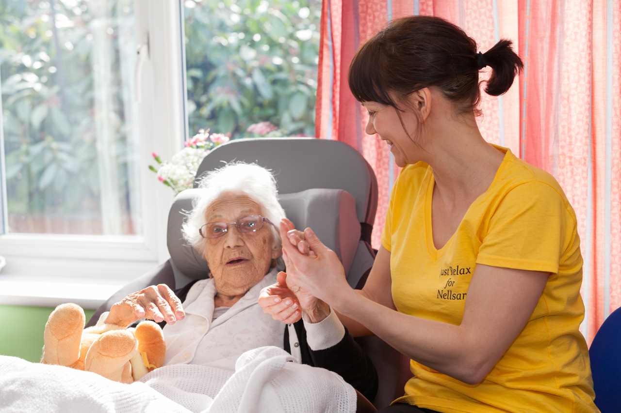 One of our ladies receiving a relaxing hand-massage from Nina (Well-Being Team) in the lounge at Abbotsleigh Care Home
