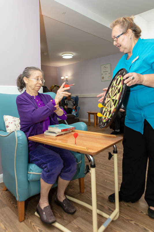 One of the ladies at Abbotsleigh Care Home playing magnetic darts
