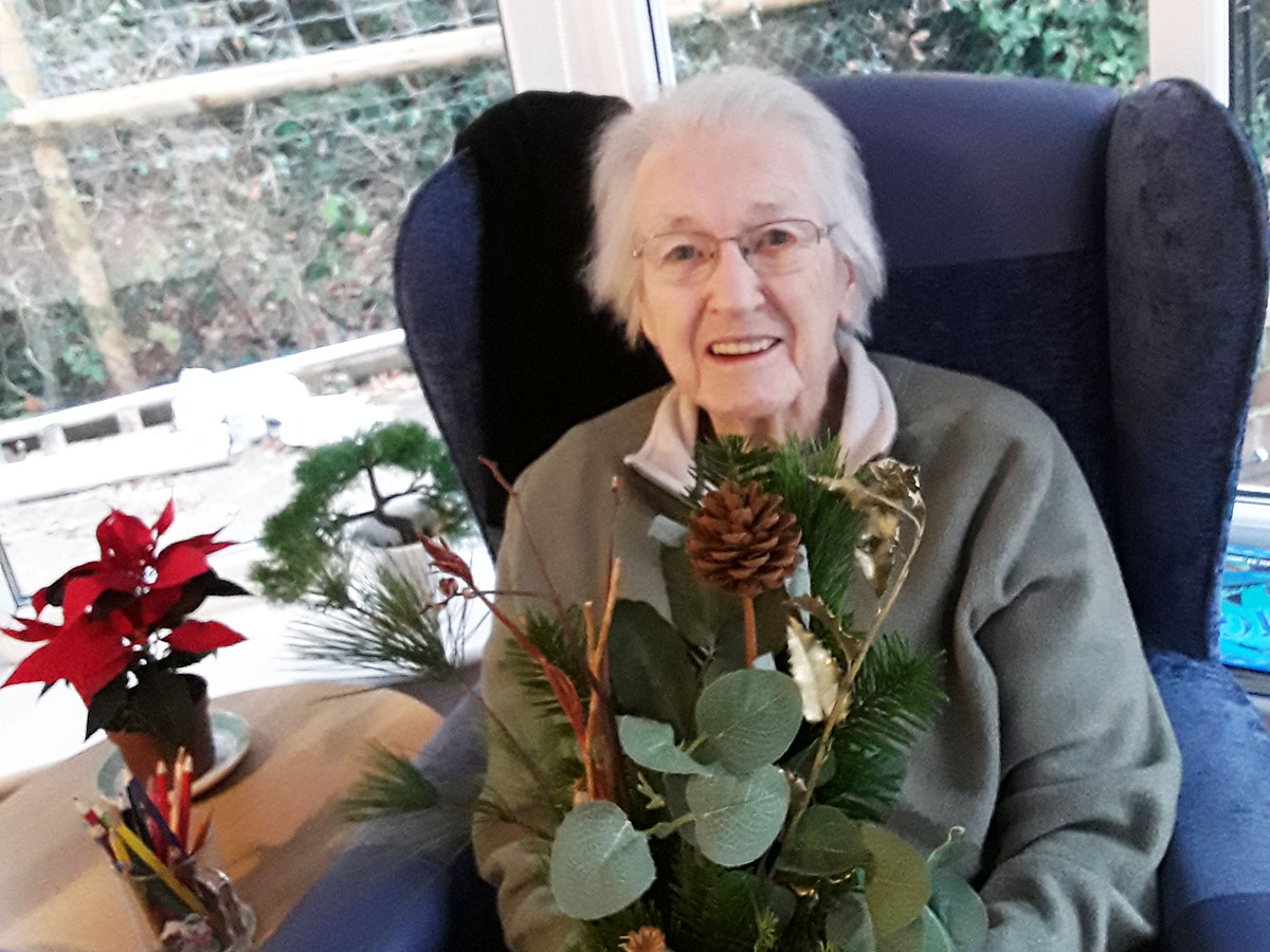 Resident with her winter-themed arrangement at Abbotsleigh Care Home